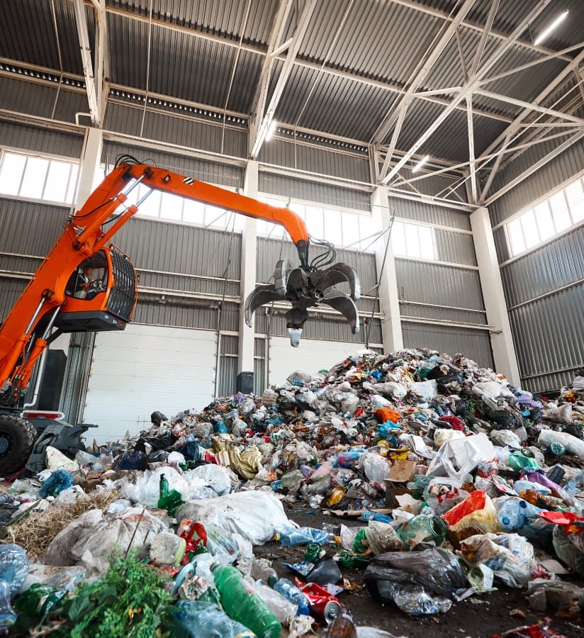 Machinery moving waste inside a recycling plant