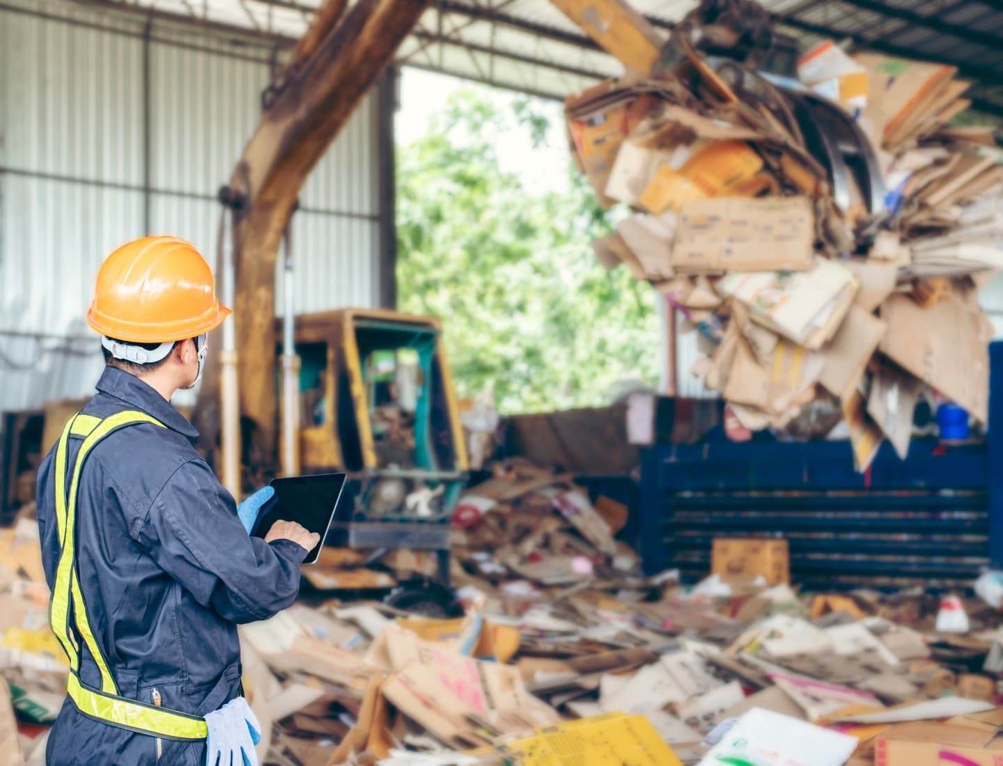 Supervisor checking inventory at a paper and cardboard recycling plant